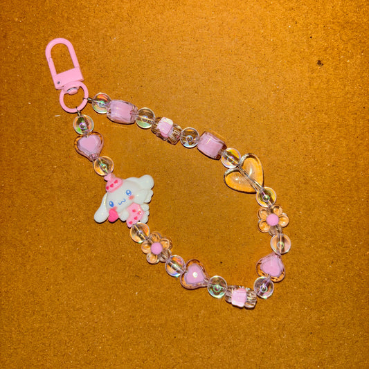 Decorative bracelet with heart-shaped beads and a pink clasp on a brown background