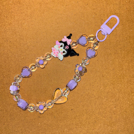 Keychain with cartoon character and beads on a brown background