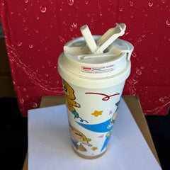 Children's cup with cartoon designs on a white surface