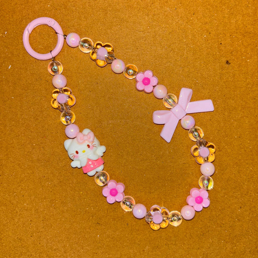 Beaded bracelet with pink and gold elements on a brown background