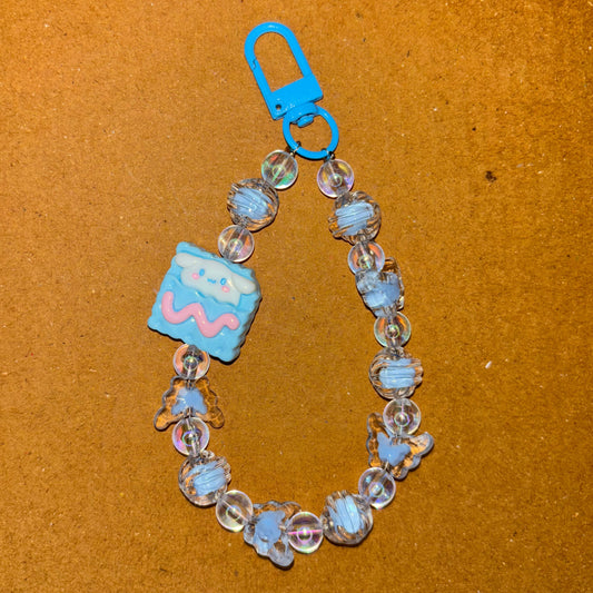 Bracelet with blue charm and clear beads on a brown surface