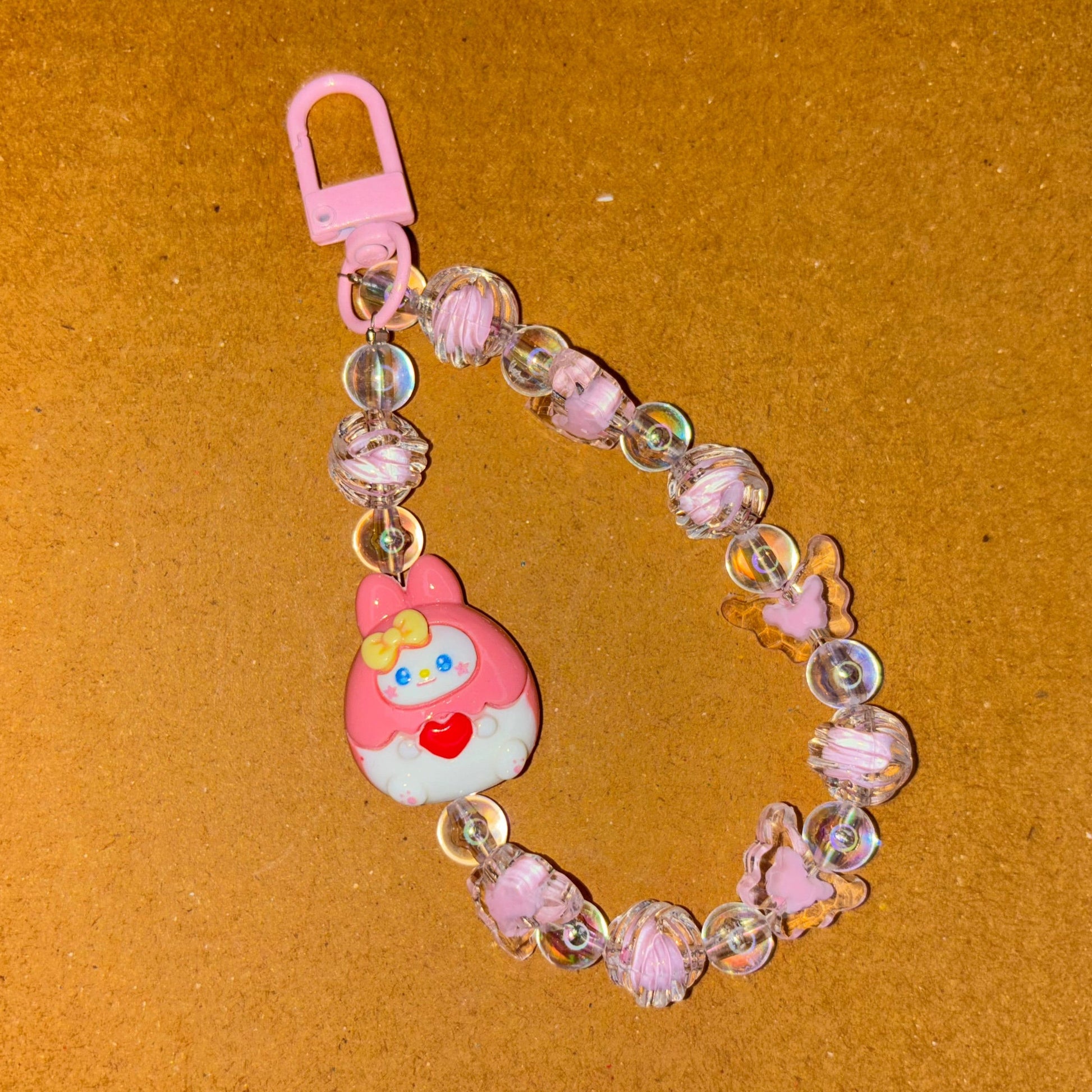 Keychain with a cartoon character and beads on a brown background
