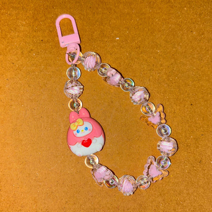 Keychain with a cartoon character and beads on a brown background