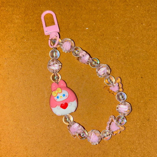 Keychain with a cartoon character and beads on a brown background