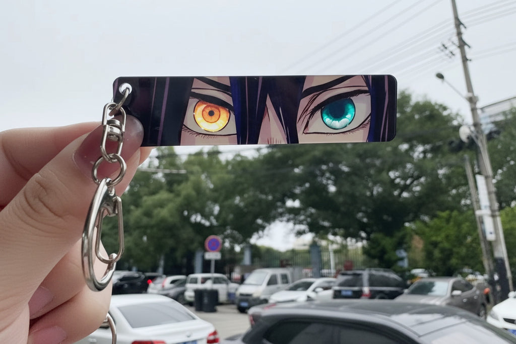 Anime character keychain with multicolored eyes held by a hand in an outdoor setting.