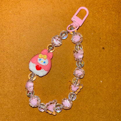 Pink baby teether with beads on a brown background
