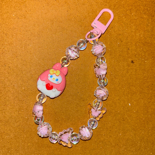 Pink baby teether with beads on a brown background